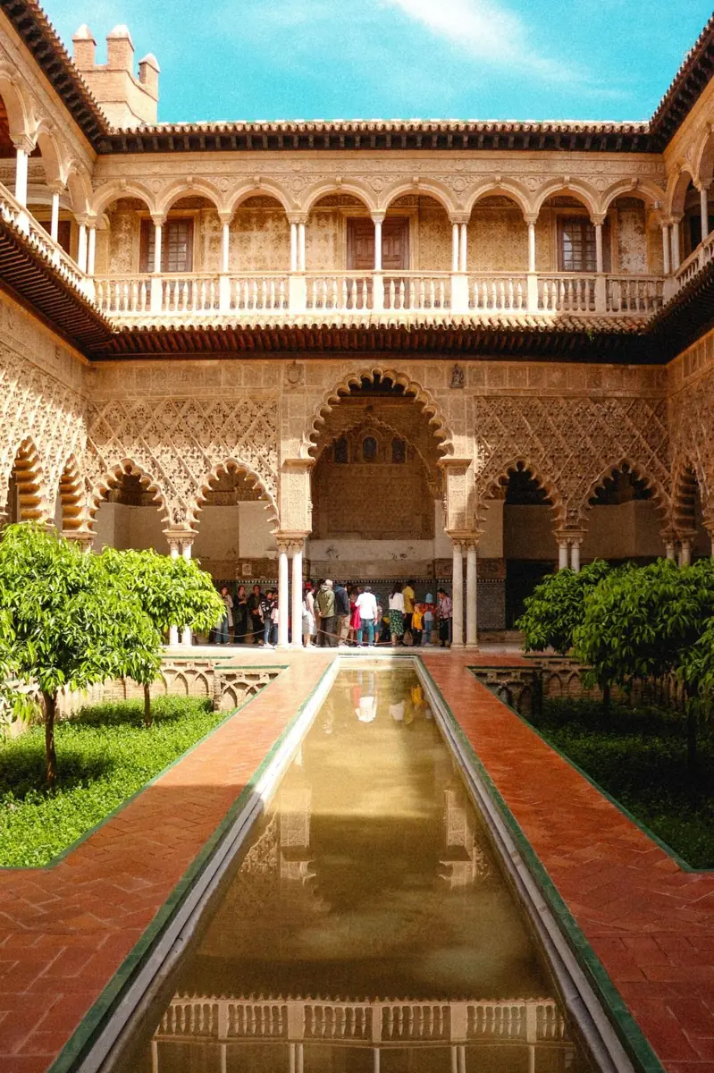 Patio de un palacio con arquerías y un estanque alargado
